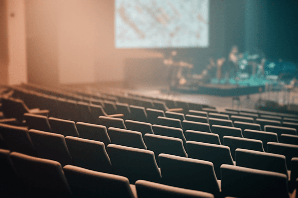 Empty modern church auditorium with contemporary seating and stage lighting, representing the congregation engagement challenge pastors face